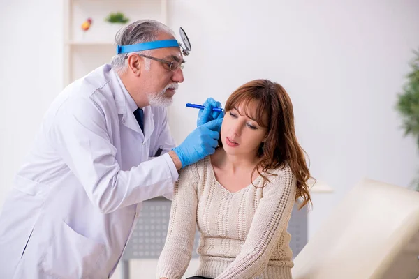 Genç bir kadın yaşlı erkek doktor otorhinolaryngologist 'i ziyaret ediyor. — Stok fotoğraf