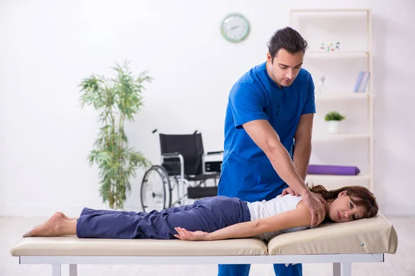 Verwondde vrouw bezoekt jonge mannelijke arts osteopaat — Stockfoto