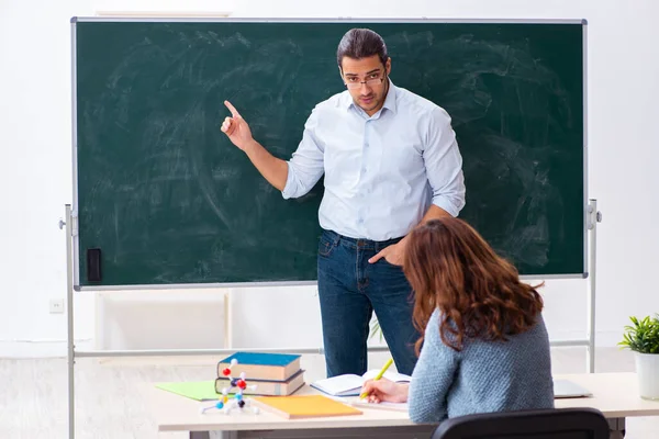 Jonge vrouwelijke student en mannelijke leraar in de klas — Stockfoto