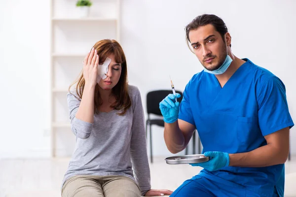 Giovane donna ferita testa visitare giovane medico maschio — Foto Stock