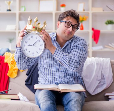 Genç adam dağınık bir odada çalışıyor.