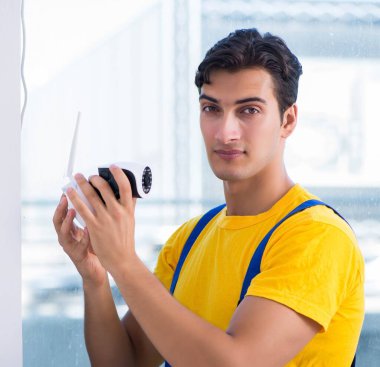 Müteahhit ofise güvenlik kamerası yerleştiriyor.