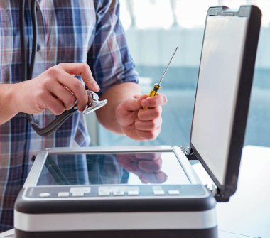 Tamirci bozuk renk yazıcısını tamir ediyor