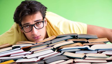 Sınavdan önce okumak için çok fazla kitabı olan öğrenci