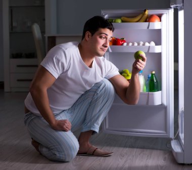 Buzdolabındaki adam gece yemek yiyor.