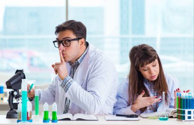 Laboratuvarda deney yapan iki kimyager.