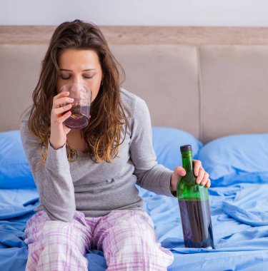 Evde alkol alan genç bir kadın depresyonda.