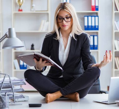 İş kadını ofiste meditasyon yaparken hayal kırıklığına uğradı