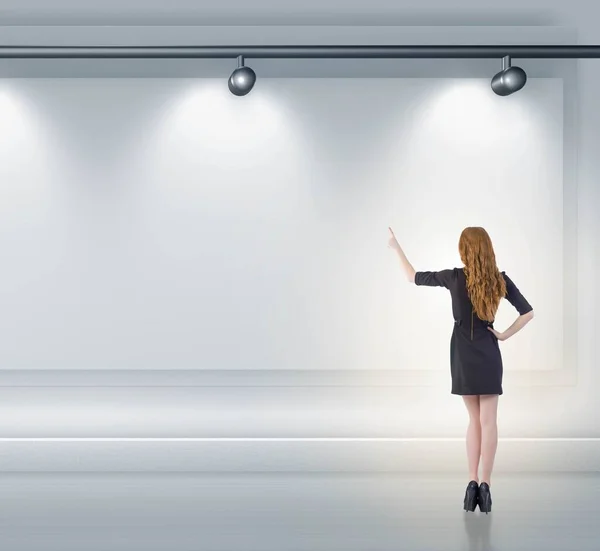 Affärskvinna trycka på virtuell knapp på väggen upplyst med spotl — Stockfoto