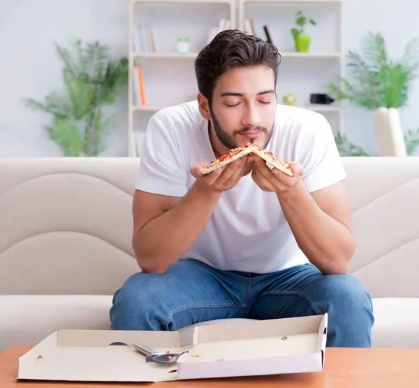 Hombre comiendo pizza teniendo una comida para llevar en casa descansando relajado — Foto de Stock