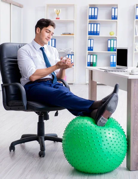 Joven empresario haciendo deporte estiramiento en el lugar de trabajo — Foto de Stock