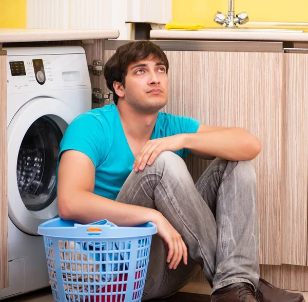 Mladý manžel muž dělá prádlo doma — Stock fotografie