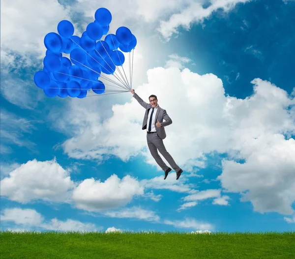 Hombre de negocios volando globos en día brillante — Foto de Stock