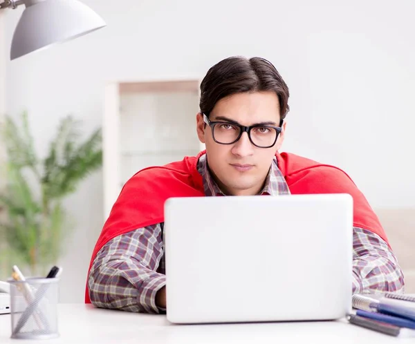 El estudiante súper héroe con un ordenador portátil estudiando la preparación para el examen — Foto de Stock