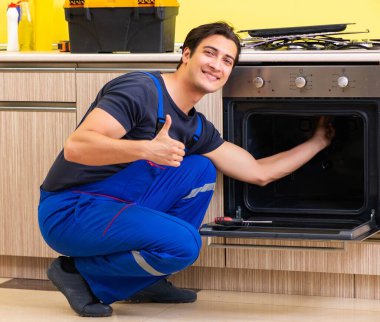 Genç müteahhit mutfak mobilyalarını monte ediyor.