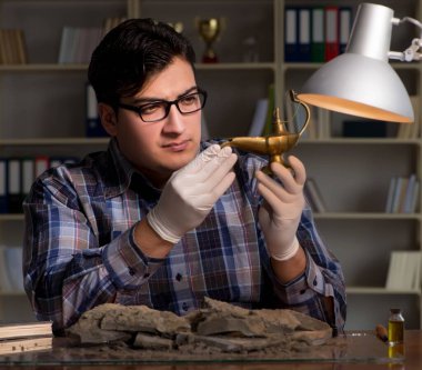 Arkeolog geç saatlere kadar ofiste çalışıyor.