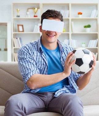 Sanal gerçeklik gözlüğü takan bir adam futbol maçı izliyor.