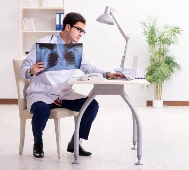 Hastane odasında çalışan yakışıklı genç bir doktor.