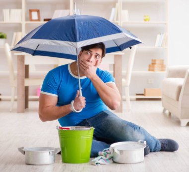 Evdeki adam, komşu sel sızıntısıyla uğraşıyor.