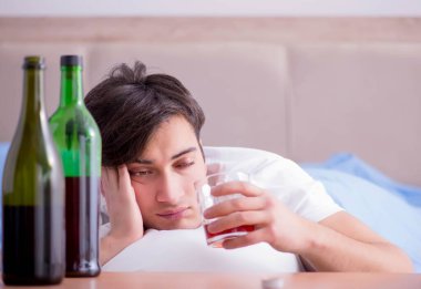Yatakta içen alkolik adam depresyona giriyor.