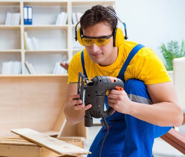 Tamirci marangoz bir seçimle tahta tahtayı kesiyor.