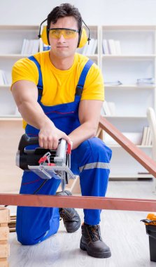 Tamirci marangoz. Dolaşım halindeki tahta testereyi kesiyor.