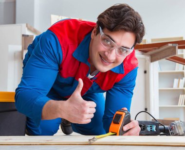 Genç marangoz ahşap kalaslarla çalışıyor.