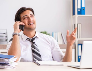 Genç yakışıklı işadamı ofiste çalışıyor.