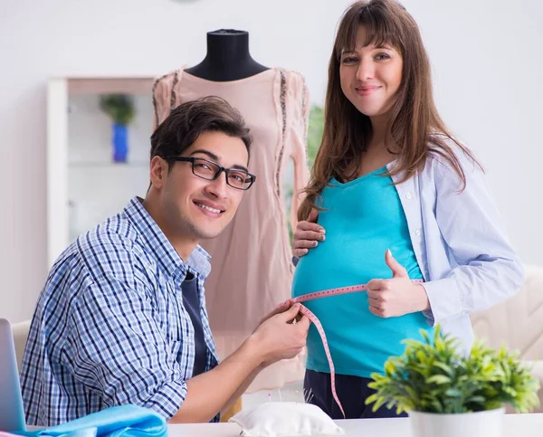 Беременная женщина, навещающая портного для новой одежды — стоковое фото