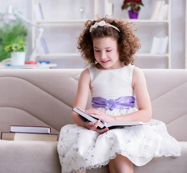 Klein mooi meisje die thuis boeken leest — Stockfoto