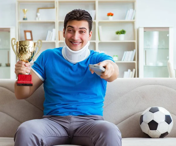 Uomo con infortunio al collo guardando calcio a casa — Foto Stock