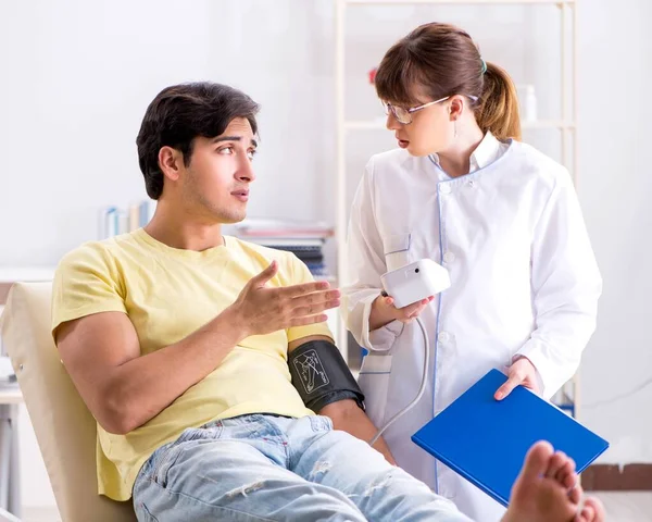 Young doctor checking patients blood pressure — Stock Photo, Image