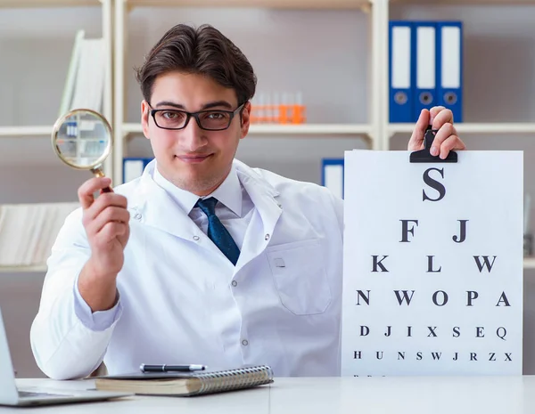 El médico óptico con carta gráfica que lleva a cabo una prueba ocular che —  Fotos de Stock