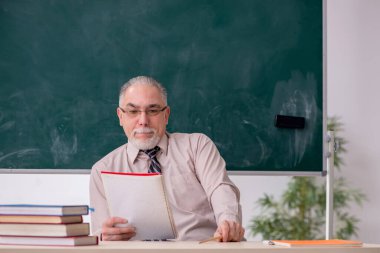 Sınıftaki yaşlı erkek öğretmen.