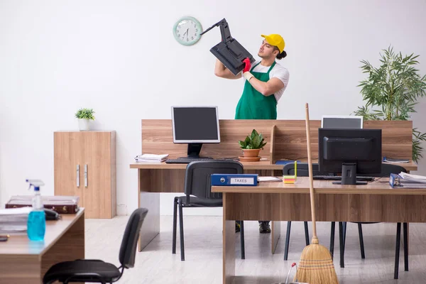 Jovem empreiteiro limpando o escritório — Fotografia de Stock