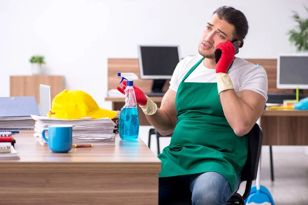 Jonge mannelijke aannemer schoonmaken van het kantoor — Stockfoto