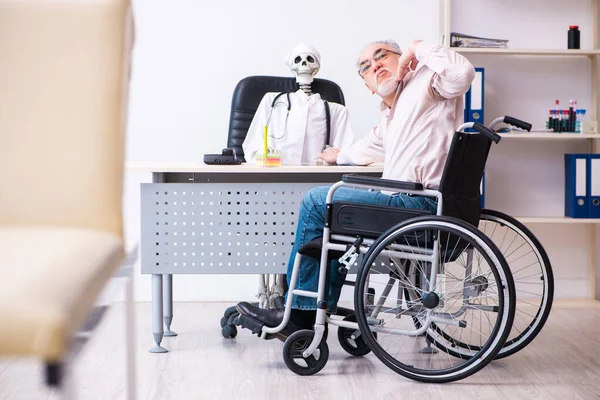 Старик в инвалидной коляске навещает мёртвого доктора — стоковое фото