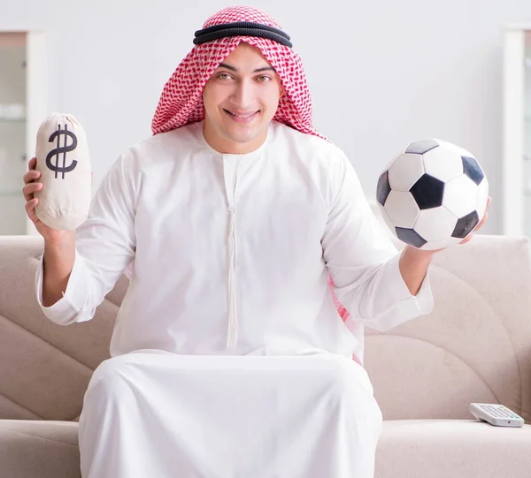 Νεαρός Άραβας που βλέπει ποδόσφαιρο καθισμένος στον καναπέ — Φωτογραφία Αρχείου