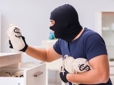 Soyguncu kar maskesi takıp değerli şeyler çalıyor.