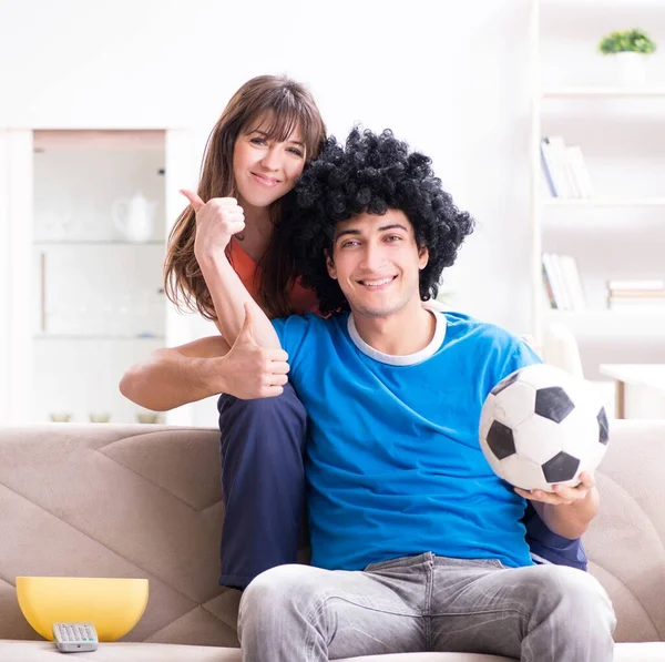 年轻人和他的妻子在家里看足球 — 图库照片