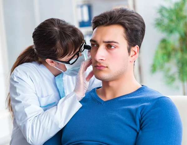 Médico revisando el oído de los pacientes durante el examen médico —  Fotos de Stock