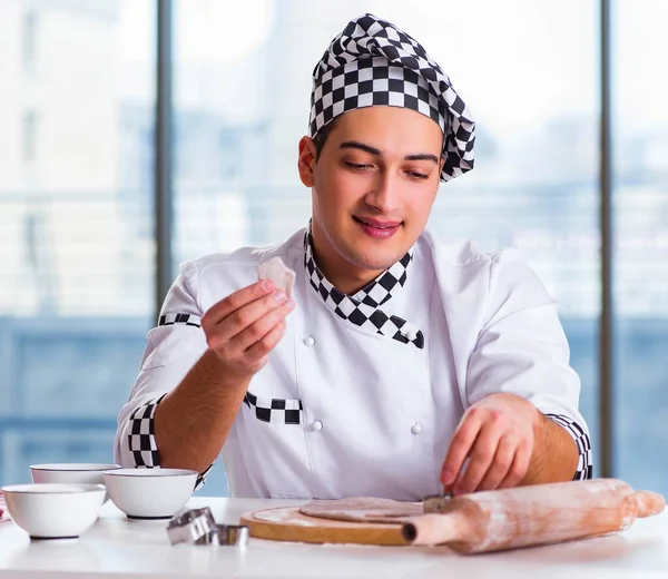 Young man cooking cookies in kitchen