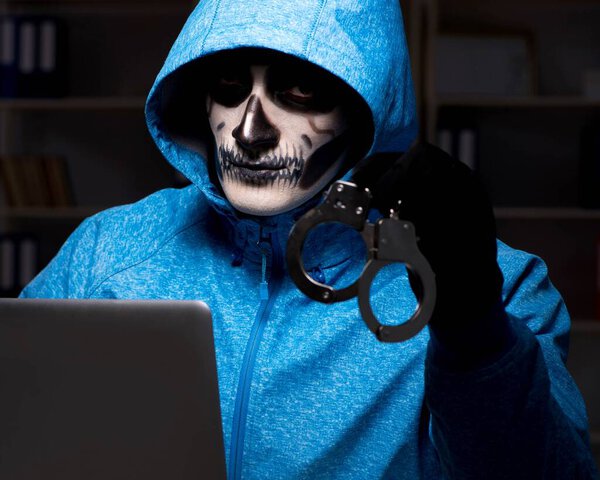 Scary hacker hacking security firewall late in office