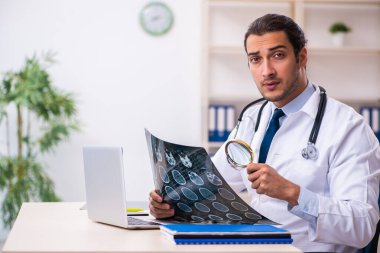 Klinikte çalışan yakışıklı genç bir doktor.