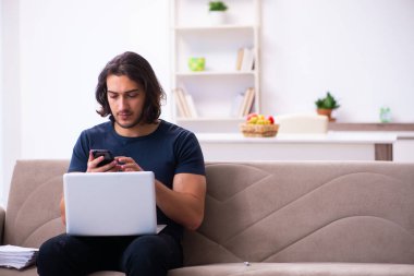 Evden çalışan genç bir adam.