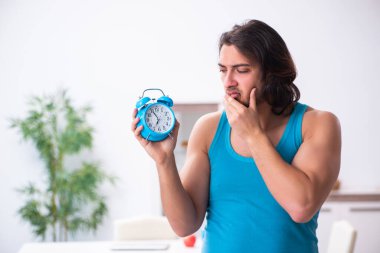 Genç adam evde uyanıyor.