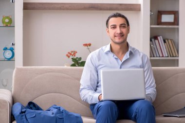 Evde çalışan genç bir erkek.