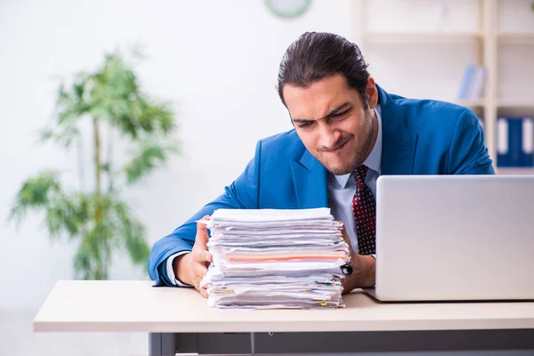 Joven empleado masculino infeliz con el trabajo excesivo — Foto de Stock