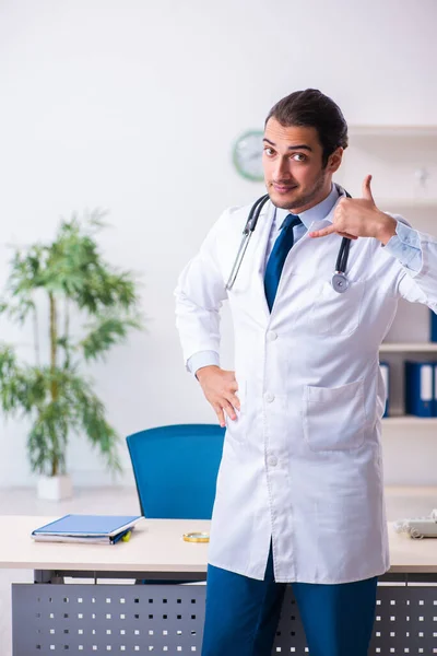 Joven hombre guapo médico que trabaja en la clínica —  Fotos de Stock