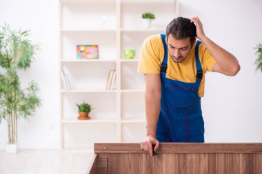 Genç erkek marangoz içeride çalışıyor.